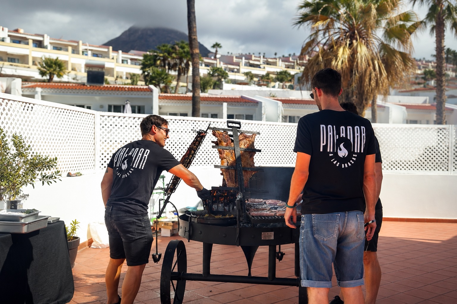 Equipo de Paladar a las Brasas asando a la estaca en una terraza en Tenerife